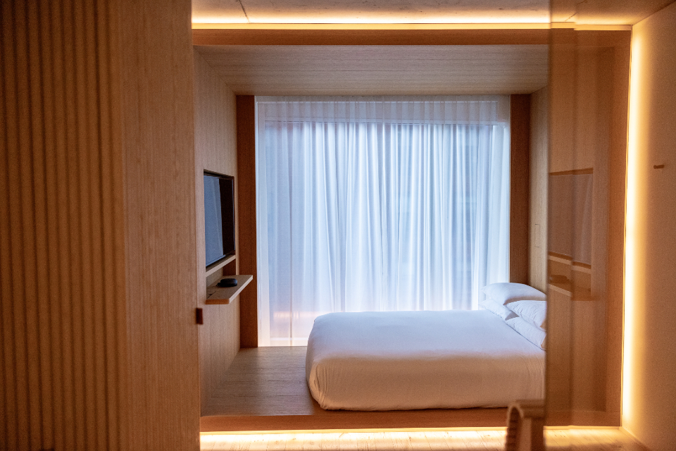 Timber-panelled room with concealed cove lighting and sheer curtains