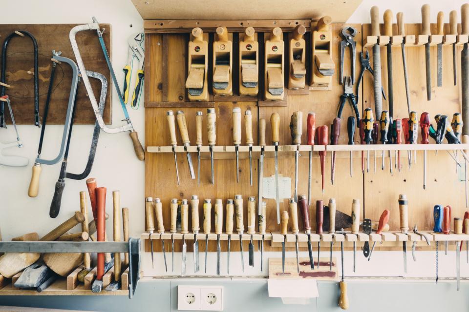 Chisels, planes and saws hung on a workshop wall