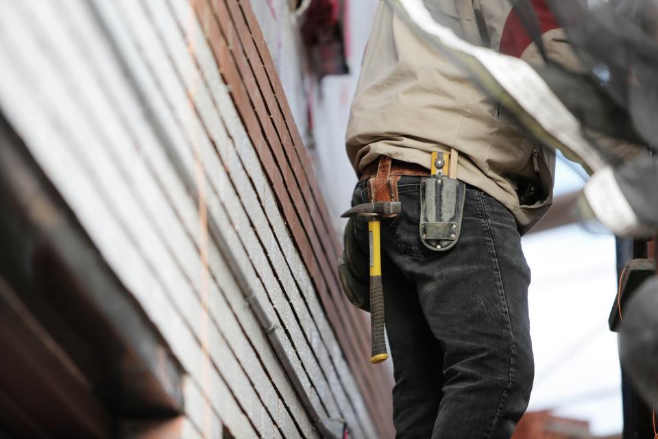 Builder with a tool belt at work on a job site