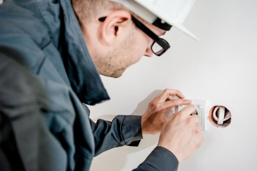 Electrician fitting a wall outlet