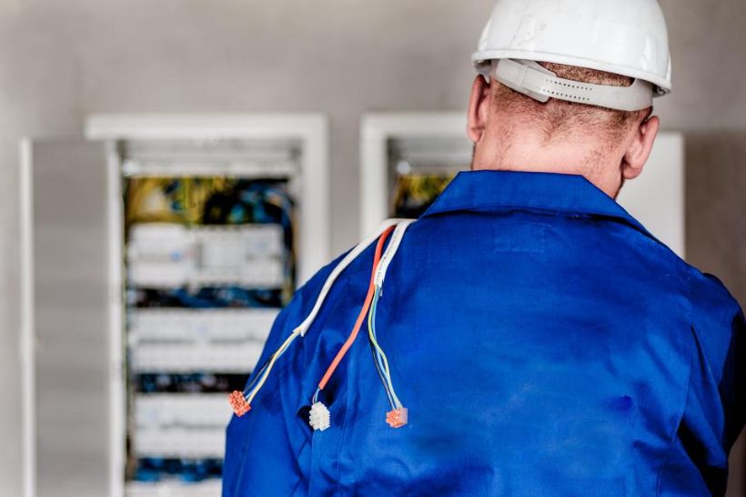 Electrician working at an open electrical panel