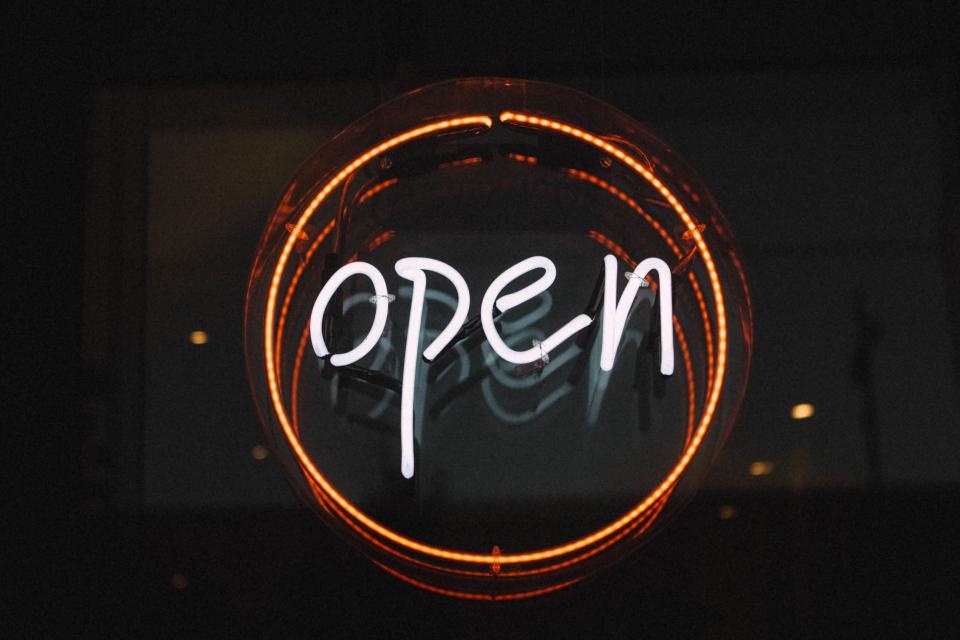 Neon sign reading open, glowing inside a ring of light