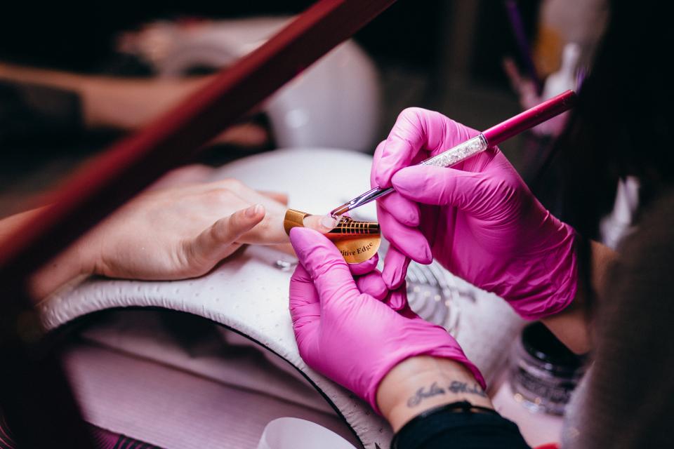 Nail technician giving a manicure at a salon table